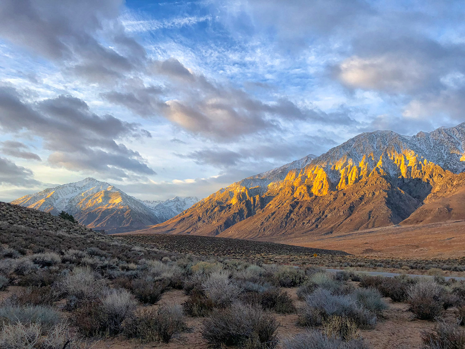A stripe of sunlight hits clouded mountains