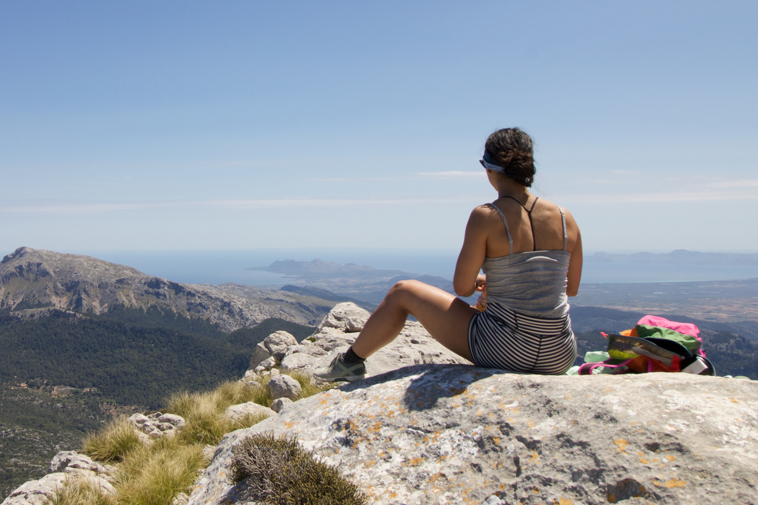 Woman on a rock outcropping looking out on a view in Mallorca Spain